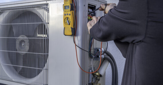 HVAC 911 | HVAC Contractor Referral Service | HVAC Service Tech Repairing A Heat Pump | Heat Pump Repair, Installation, Maintenance